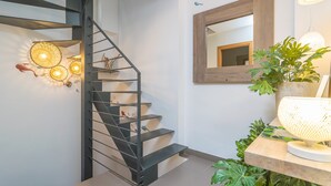 A modern staircase with a metal railing, a wall-mounted mirror, and decorative wall sconces. - MAR COLONIA - Apartment with sea views in Colonia de Sant Jordi. Free WiFi (Ses Salines)