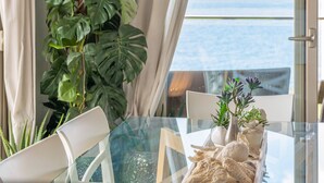 A glass table with chairs, a plant, and decorative items. - MAR COLONIA - Apartment with sea views in Colonia de Sant Jordi. Free WiFi (Ses Salines)