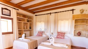 A hotel room with two beds, each with a towel swan, a wooden shelf unit, and a window with curtains. - Torre Dorada, just 150 metres from Es Morer Vermell beach in Alcudia (Alcudia)