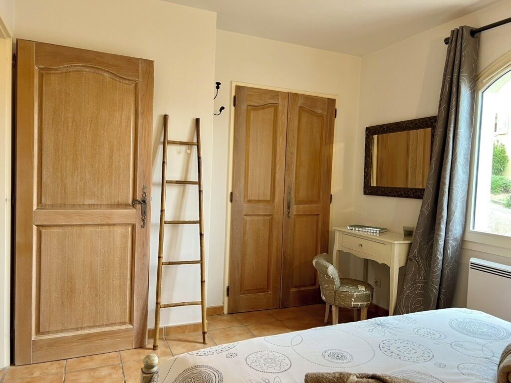 Une chambre à coucher comprenant un lit, un bureau, une chaise et deux armoires.