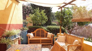 An outdoor seating area with a table, chairs, and a bowl of fruit. - The Ancient House, wonderful Sardinia! (Masainas)