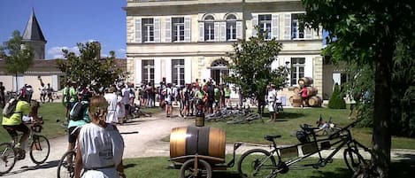 Un bâtiment historique doté d’une cour intérieure, entouré d’arbres et de vélos.