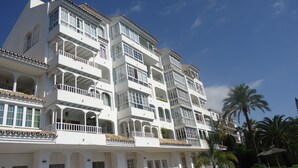 Ein mehrstöckiges Hotel mit Balkonen, großen Fenstern und blauem Himmel.