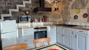 A kitchen with white cabinets, a microwave, a stove, and a sink. - Stunning charming detached house with private heated pool (La Roque-Sainte-Marguerite)