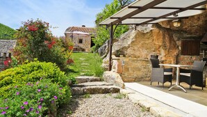 A patio area with a table and chairs, surrounded by a garden with various plants and flowers. - Stunning charming detached house with private heated pool (La Roque-Sainte-Marguerite)