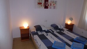 A bedroom with a bed, two bedside tables, and a wall-mounted light fixture. - SOL Y MAR PLAYA – Beachfront apartment with spacious terrace (El Campello)