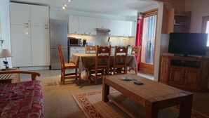 A compact living space with a dining area, kitchen, and a TV. - fantastic location, 3 minutes walk to piste & village - sleeps 8, wifi & views! (RA)