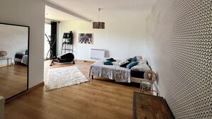 Een moderne slaapkamer met een bed, een stoel, een radiator en een muur met een structuur.