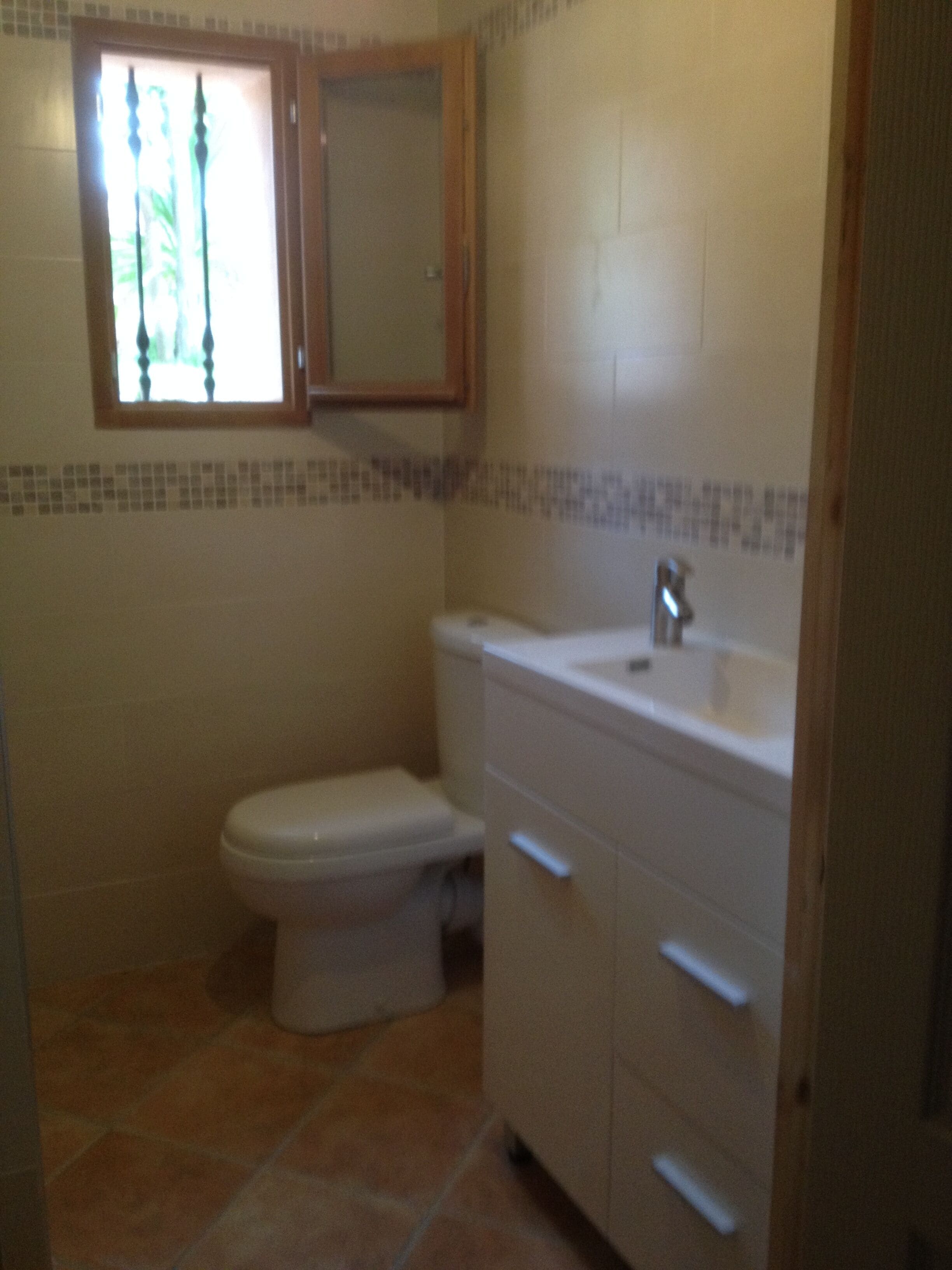 Un bagno con il water, un lavandino e un armadietto.