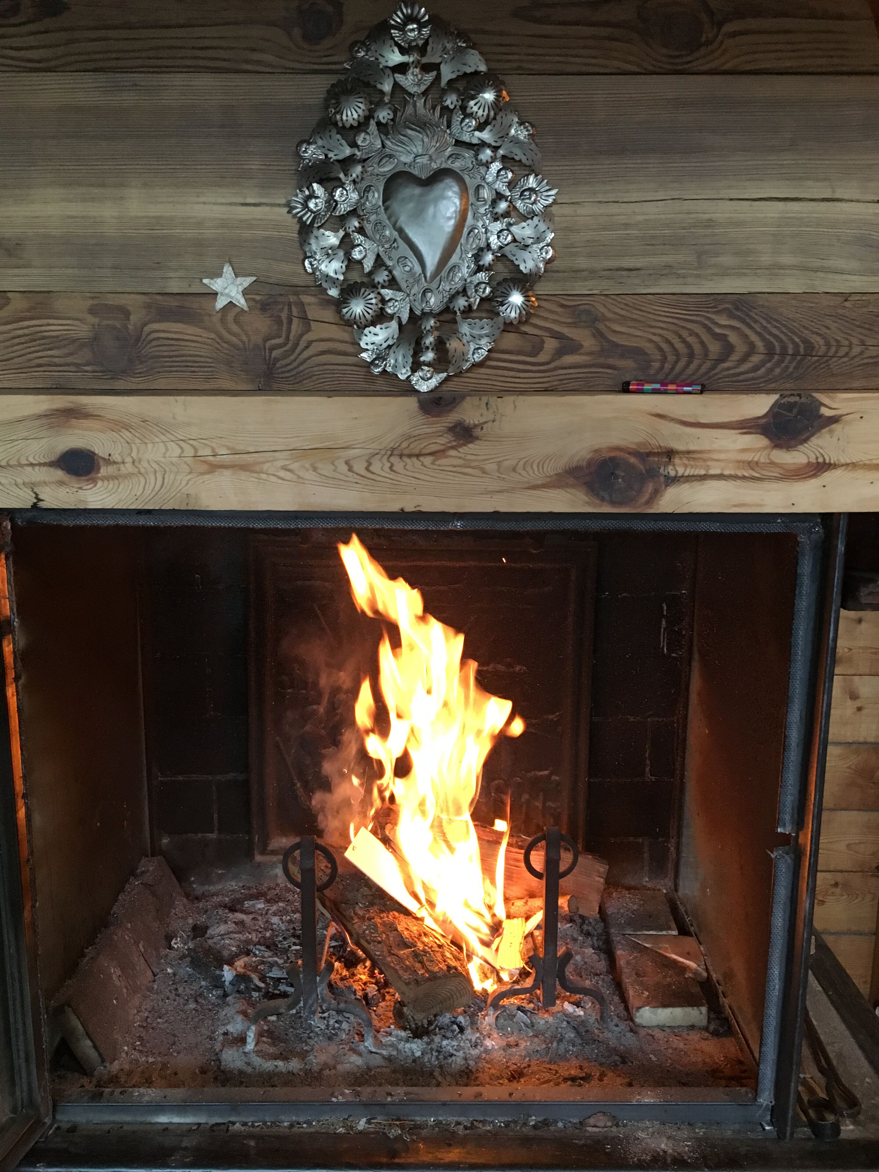 A fireplace with a decorative heart-shaped ornament above it.