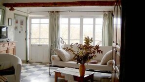 A living room with a sofa, a coffee table, and a television on a cabinet. - Roussillon Gargas: Mansion - Roussillon (Gargas)