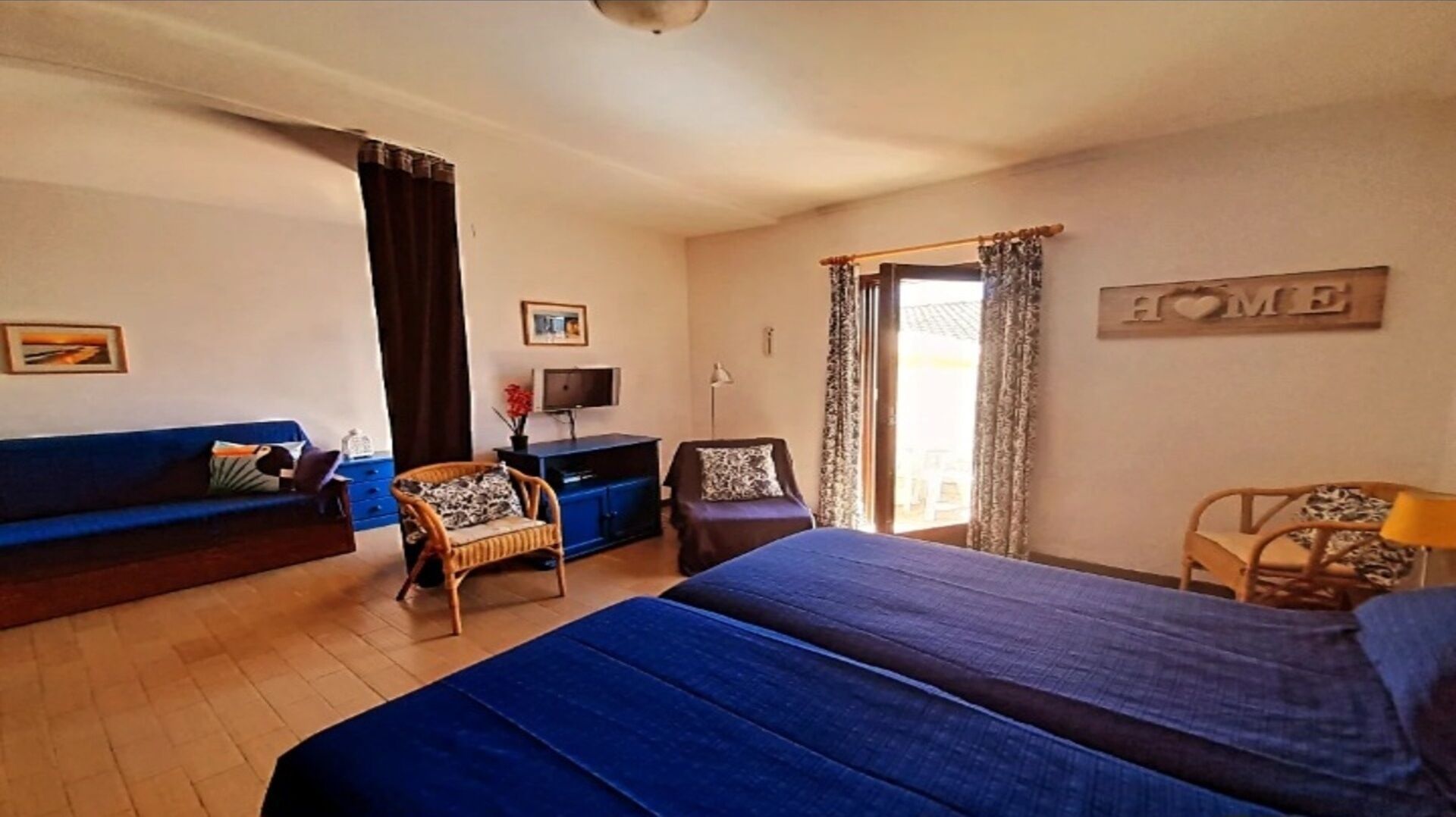 A hotel room with a bed, a sofa, a desk, and a chair.