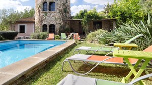 A pool area with lounge chairs and a stone tower structure. - LA TORRE  Ref. VP86 (Pollensa / Pollença)