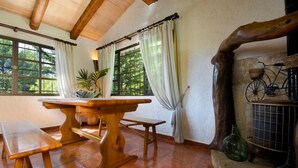 A rustic dining area with a wooden table and benches, large windows with curtains, and a vintage bicycle. - LA TORRE  Ref. VP86 (Pollensa / Pollença)