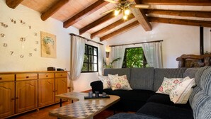 A cozy living room with a wooden ceiling, a checkered coffee table, a sofa with patterned cushions, and a wooden cabinet. - LA TORRE  Ref. VP86 (Pollensa / Pollença)