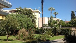 A residential area with a well-maintained garden, palm trees, and a clear blue sky. - Antibes - attractive apartment with panoramic views & 300m from 2 beaches (Antibes)