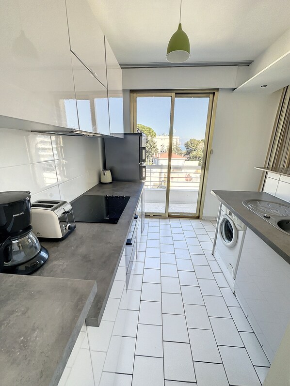 A modern kitchen with a built-in washing machine, a coffee maker, and a toaster.