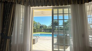 A room with a large sliding glass door leading to a pool area. - Beautiful 4 bedroom villa in the Alto Golf (ALVOR)