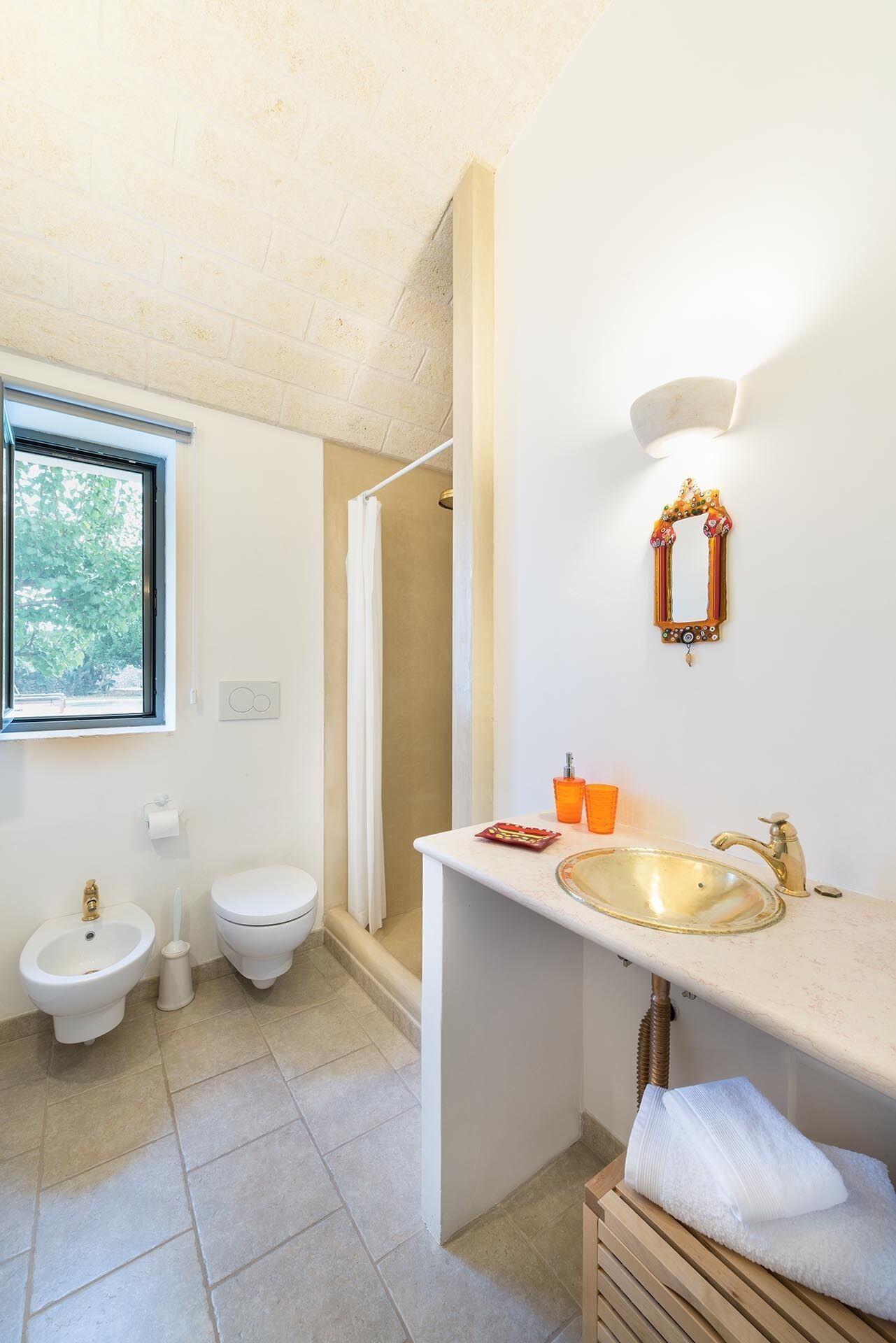 Ein Badezimmer mit einer Bidet, Toilette, einem Waschbecken und einer Dusche.