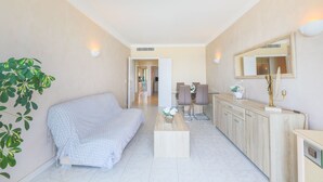 Una sala moderna con un sofá, una mesa de centro y un comedor con sillas y una mesa.