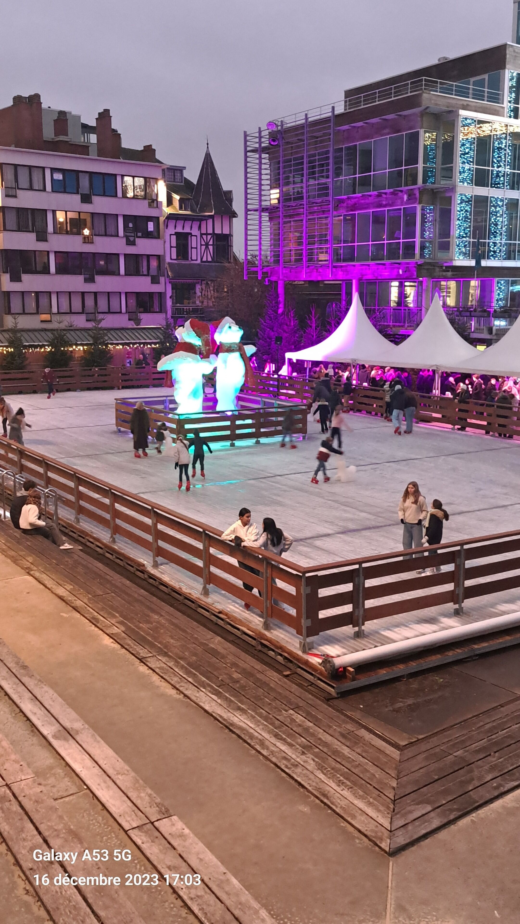 An outdoor plaza with a fountain, benches, and people.