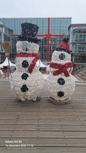 Two snowmen statues on a wooden deck with a modern building in the background. - Apartment/ flat - (Coxyde)