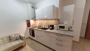 A compact kitchen with a built-in oven, a microwave, and a coffee maker. - Luxury Penthouse Apartment with Panoramic Sea Views (Sveti Vlas)