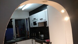 A compact kitchen with white cabinets, a microwave, a stove, and a washing machine. - Disabled friendly - LUXURY bungalow / Villa , San Eugenio,  Costa Adeje  (Costa Adeje)