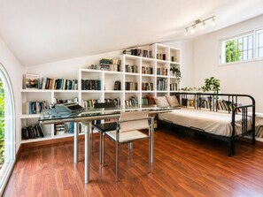 Une pièce comprenant un lit, un bureau avec une chaise, une bibliothèque et une fenêtre.