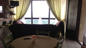 A dining area with a round table, chairs, a remote control, and a bottle on the table. - House / Villa - SampzonHouse with garden (Sampzon)