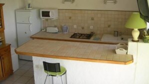 A small kitchen with a microwave, toaster, and a small sink. There is a chair and a green lamp on the counter. - House / Villa - SampzonHouse with garden (Sampzon)