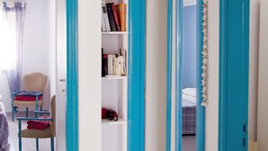 A room with a bookshelf, a chair, and a mirror. - Casa Palme, APARTMENT AT SEA (Marzamemi)