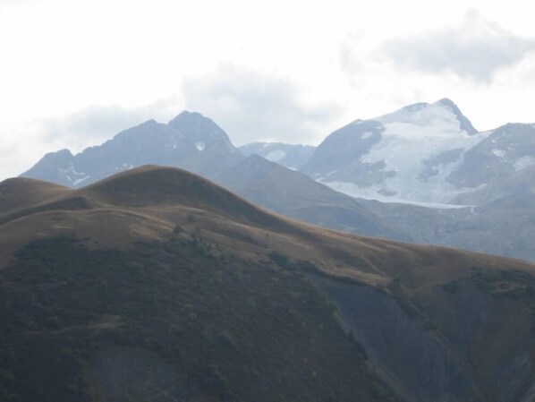 A mountainous landscape with rolling hills and snow-capped peaks. - Chimney sweep in the hamlet of La Chal (Saint-Jean-D'arves)