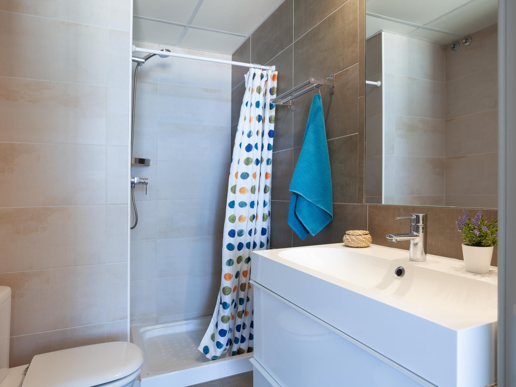 Een badkamer met douche, toilet en wastafel.