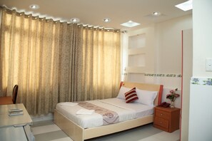 Un dormitorio ordenado con cama, mesita de noche y una silla.