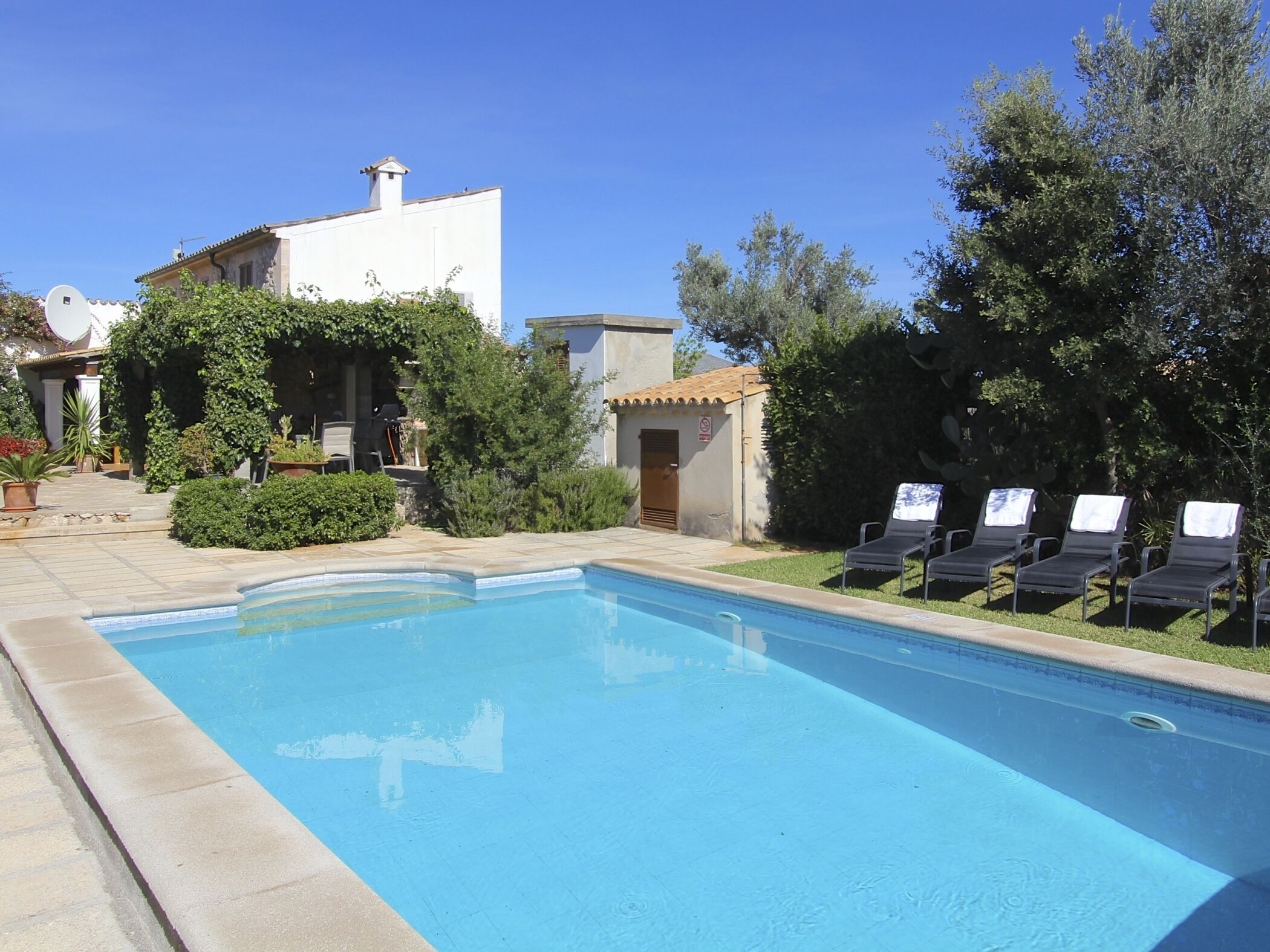 A swimming pool with lounge chairs and a building in the background.