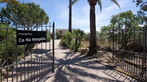 Ein begrenzter Eingang zu einem Anwesen namens 'PrestigeVillas' mit einem Schild, das 'Ca Na Margalida' anzeigt.