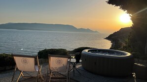 A hot tub and two chairs by a waterfront with a sunset view. - MAGICAL HOUSE " MARICA" WITH PRIVATE BEACH, PARADISE  FAR AWAY FROM STRESS LIFE (Klek)