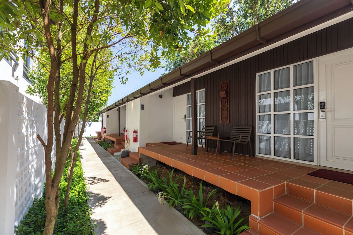A building with a covered porch, outdoor seating, and a fire extinguisher.