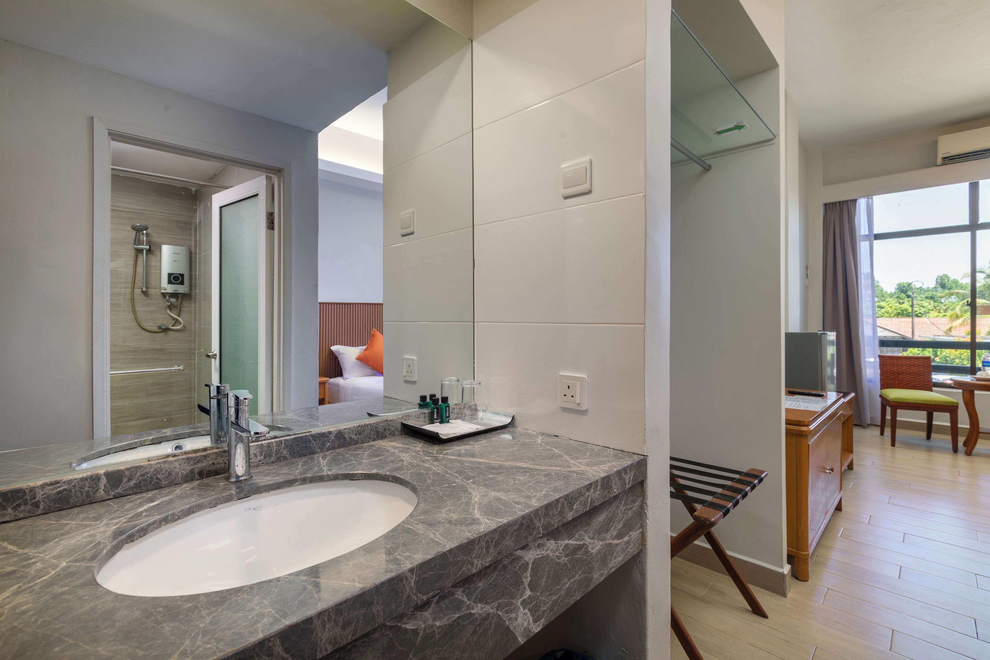 A modern bathroom with a marble sink, a shower, and a large mirror.