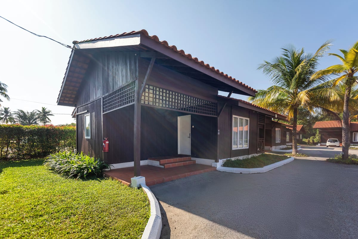 A modern two-story house with a tiled roof, a covered porch, and a well-maintained lawn.