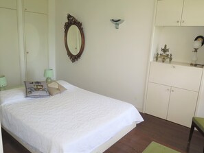 A bedroom with a bed, a dresser, a mirror, and a nightstand with lamps. - 1st Floor Apartment With Beautiful Sea View in Magnificent Character Building (Cannes)