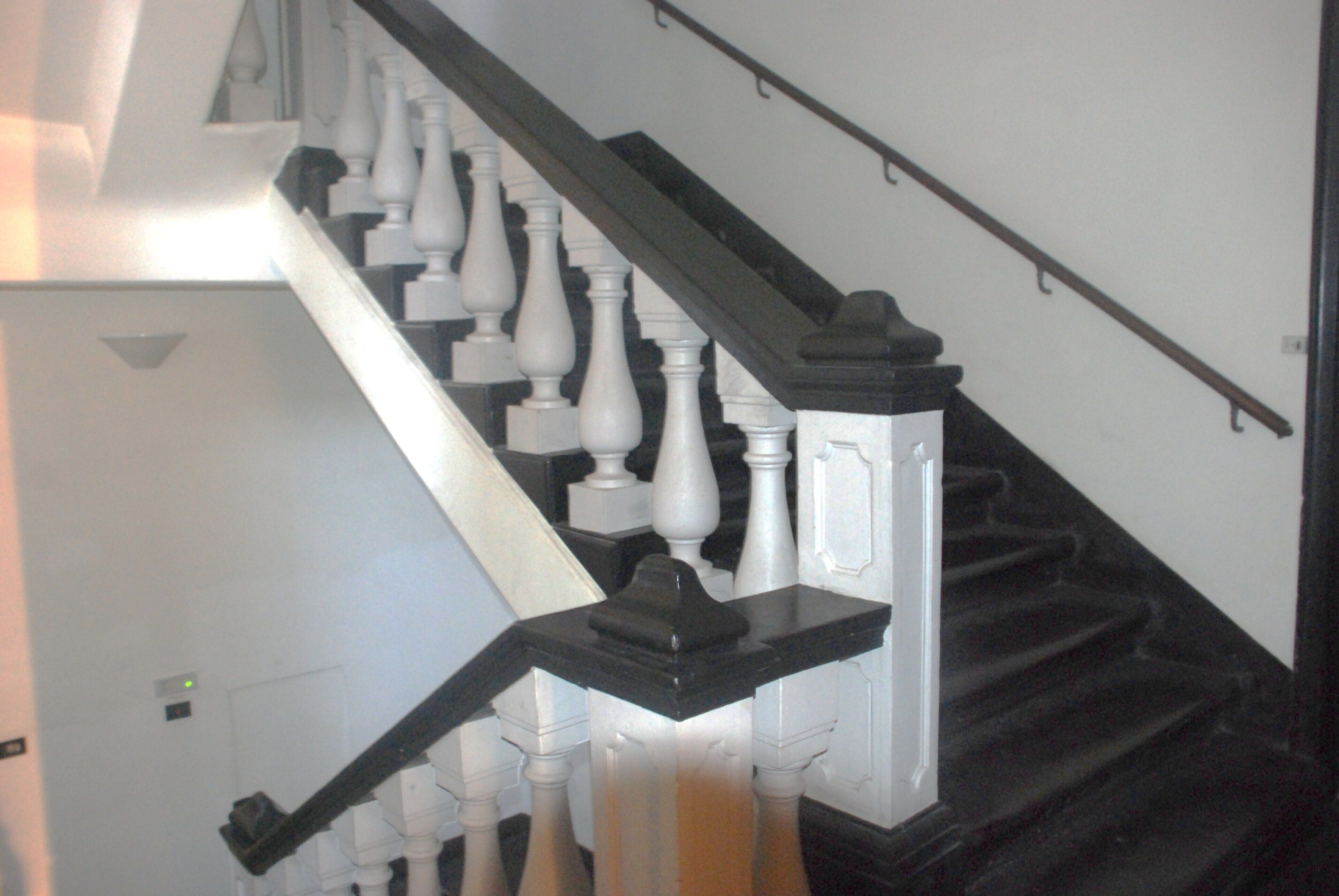 A staircase with white balusters and black handrails.