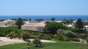 Un quartier résidentiel situé sur la côte, avec des bâtiments, de la verdure et une vue dégagée sur la mer.