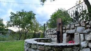 Une structure en pierre, dotée d’une grille métallique et d’une petite ouverture ornée de fleurs.