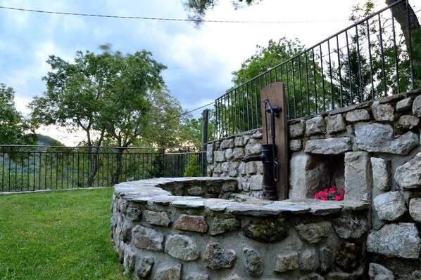 A stone structure with a metal gate and a small opening with flowers. - Saint Joseph Des Bancs: House / Villa - Saint joseph des bancs (Saint Joseph des Bancs)