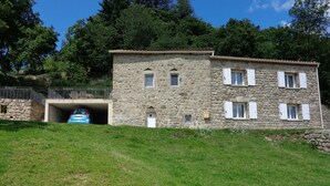 Un bâtiment en pierre doté d’un garage, d’une petite porte et d’une fenêtre.