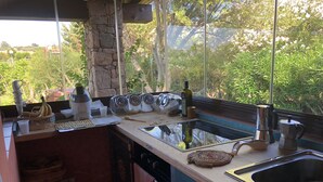 A kitchen with a stone pillar, a sink, and various kitchen items. - Punta Molara just 250 meters from the sea (San Teodoro)