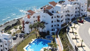 Un hotel de varios pisos con piscina, cerca de la costa.