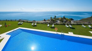 Una piscina rectangular con superficie de agua azul cristalina, rodeada por una terraza blanca.